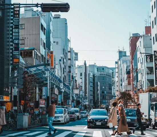 Passants sur un passage piétons, entourés d'immeubles dans la ville de Kobe, Japon